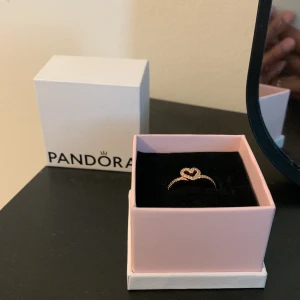 Pandora ring  - Säljer en Pandora-ring och den är, den senaste, aldrig använd. Säljer den för att jag tänkte att den kanske är för yngre tjejer eftersom den har ett hjärta i sig. Om du är från Sverige Stockholm, hör av dig så kan vi prata i detalj. Storlek 48 i ringstorl