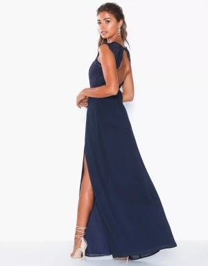 Balklänning - Säljer min fina balklänning som aldrig kom till användning. Klänningen har spetsdetaljer, slits och öppen rygg. Fler bilder kan skickas. Priset kan diskuteras