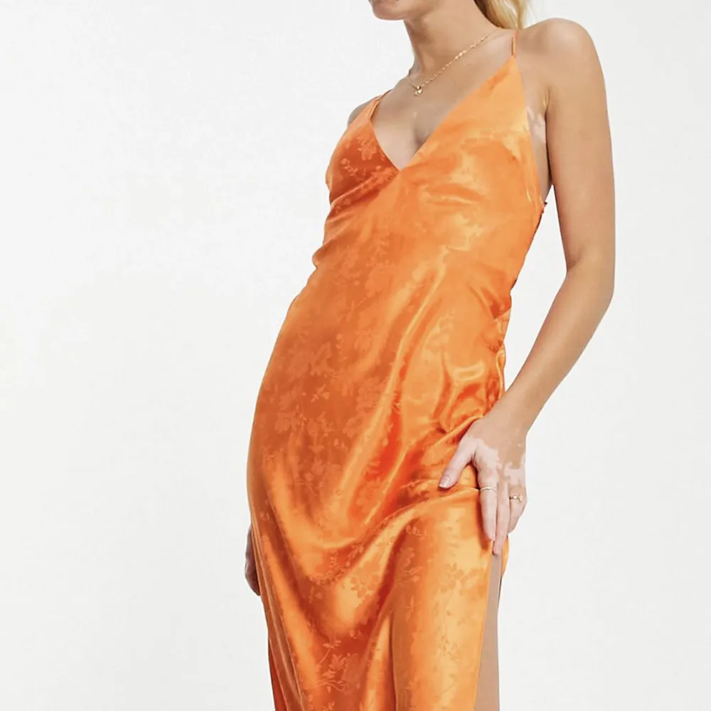 Helt ny klänning, aldrig använd. Superfin passform, öppen rygg med snörning och slits. Vacker orange färg med otroligt fint men subtilt mönster. . Klänningar.