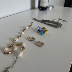 Smycken (alla på bilden) - Köp ett paket med smycken. Ok kvalité, vissa använda och vissa inte. Halsband, armband, färgglada ringar, earcuffs.