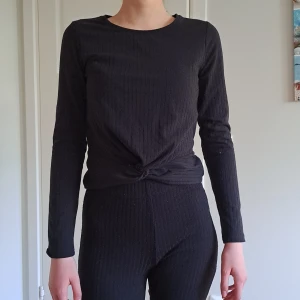 Svart tunntröja  - Svart tunntröja med en knut längst ner. Bra skick. 