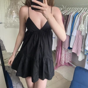 Zara klänning svart - Supersnygg klänning från Zara, perfekt till sommaren och till fest!! Säljer då jag tycker den är lite för kort på mig som är 179cm lång🫶🏼❤️ Råkade knyta rosetten snett bak på bilden🙈