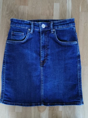 Mörkblå jeanskjol - Mörkblå jeanskjol från Zara med snygg passform. Färgen syns bäst på sista bilden. Fint skick! 