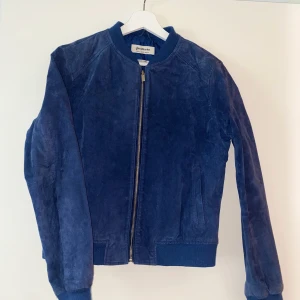 Läderjacka  - Blå läderjacka från stradivarius, sparsamt använd.  Liten i storleken 