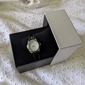 Armbandsur Tajms  - Sött litet arbandsur från Tajms. Aldrig använd, nyckick. Kommer i fin originalask med sammetskudde. Kan bli en perfekt present till födelsedag, student eller konfirmation!