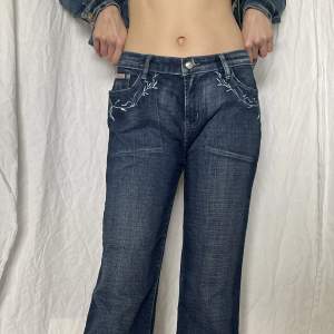 Lowrise Baggy jeans med broderat mönster på fickorna, behövt vika upp dem lite.