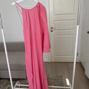 Maxiklänning i rosa från zara med straps i ryggen och en draperad arm. Storlek L.