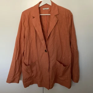 Orange linnekavaj - Jättefin orange kavaj i linneblandning, säger pga att den tyvärr inte kommer till så mycket användning. (Bild 2 är lånad för att man ska se bättre vad det är för färg)