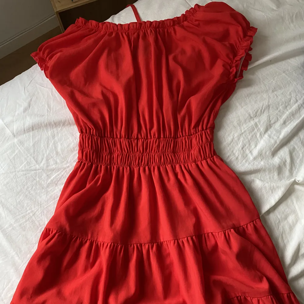Röd klänning från Daisy Grace med knytning där fram. Aldrig använd så är i nyskick. Den är i storlek xs men passar mig som är  M/L perfekt också eftersom den är så stretchig!. Klänningar.