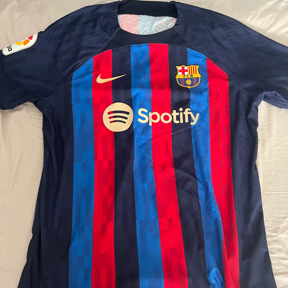 Autentisk spelarversion av Barcelonas hemmatröja 22/23   Jules Kounde på ryggen.   Använd ett par gånger ej tvättad, i köpt nyligen för 1800kr på Nike.   Storlek XL men sitter något mindre pga spelarversionen. . T-shirts.