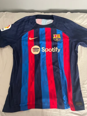 FC Barcelona Hemmatröja 22/23 Player version  - Autentisk spelarversion av Barcelonas hemmatröja 22/23   Jules Kounde på ryggen.   Använd ett par gånger ej tvättad, i köpt nyligen för 1800kr på Nike.   Storlek XL men sitter något mindre pga spelarversionen. 