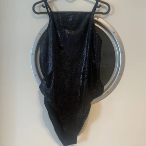 Svart glittrig body - Svart glittrig body från H&M. Storlek L men är inte så stor i storleken. Aldrig använt, bara provat på. Perfekt till festligheter! Tyvärr inte min stil längre.