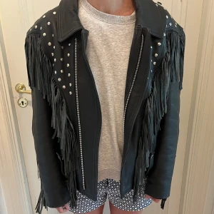 Skinnjacka med fransar och nitar  - Ascool jacka med fransar i äkta skinn! Köpt vintage men är i väldigt fint skick, ifrån märket Fuel. Nypris på deras jackor är 3000kr-5000kr. 