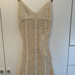 Sommarklänning  - Säljer denna stickade klänning med paljetter som passar perfekt med en bikini under 💕 Hyfsat stretchig och 81 cm lång från axelband till botten!