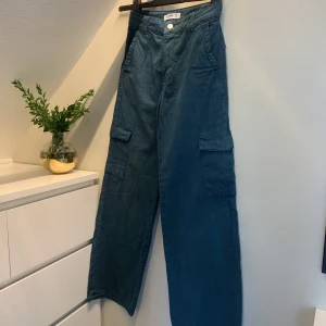 Grönblå Cargobyxor - Knappt använda byxor från Pull&Bear. Färgen är mer grönaktig i verkligheten. 