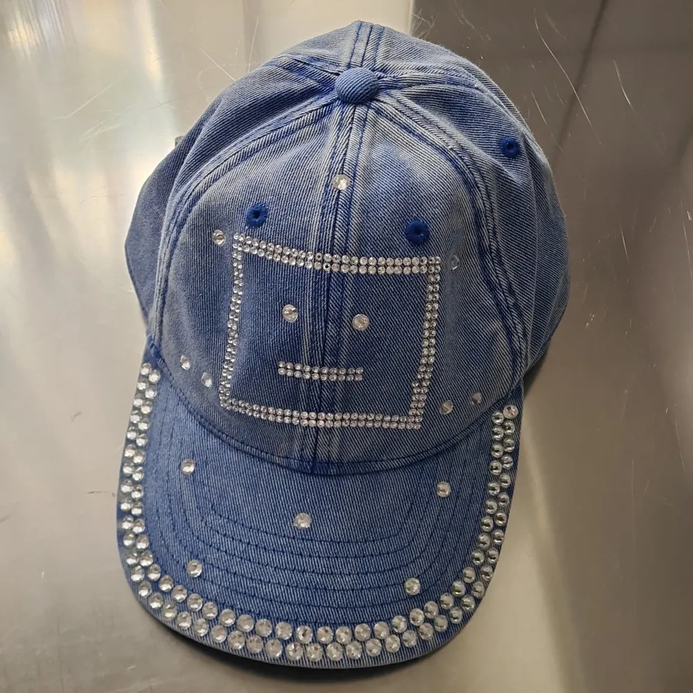 New Acne Studios cap in blue and with silver stones embellishments. The lagom face on front. One stone is loose, but there are extra silver stones in the hangtag. Can send more photos. 100% new condition. Can be slightly flexible with the price :). Övrigt.