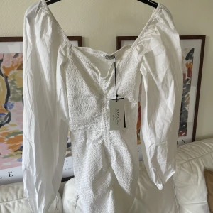 NAKD vit klänning - Vit klänning från NAKD med puffärmar. Aldrig använd, med prislapp kvar. Köptes som studentklänning men blev en annan istället 🤍Nypris ca 500:-