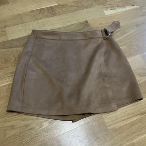 Shorts kjol - Shorts som ser ut som en kjol. Dragkedja. Tror det är mocca. Köpt på new yorker, använd en gång. 