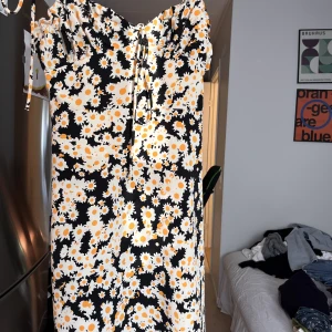 Blommig kortklänning - Blommig kortklänning från DesignBySi. Väldigt söt sommarklänning, säljer då jag inte får användning för den längre. Står ingen storlek i klänningen men skulle säga att den motsvarar en XS/S. Bra skick!