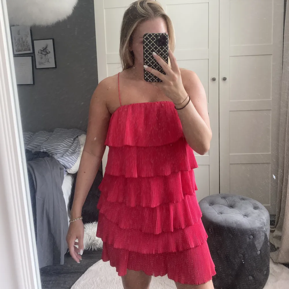 Säljer denna fina volangklänning som tyvärr inte kommer till användning. Lite röd/rosa. Den går också att knyta som en bandeu om man inte vill ha banden! . Klänningar.