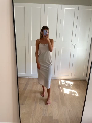 Beige klänning - Beige och väldigt skön klänning från HM. Har en slits längst höger ben och justerbara axelband. Tyget är dubbelt på över bysten. Sparsamt använd och inga anmärkningar. 🤍 Storlek S 