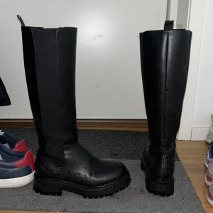 Boots höga stövlar  - Svarta stövlar från zalando (blöta för tvätta dom precis från lera, grus) Köpt för runt 800kr. 