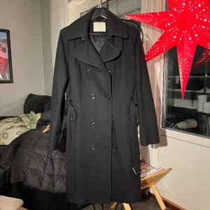 Trenchcoat - Trenchcoat i ull från Bruuns Bazaar, i gott skick. Storlek 40.