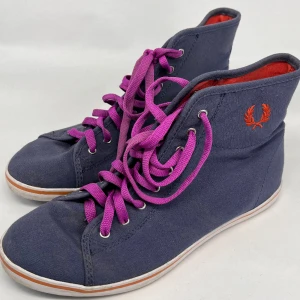 Fred Perry skor - Höga sneakers i canvas från Fred Perry i fint skick. Mörkblå-lila färg med lila skosnören. Storlek 39