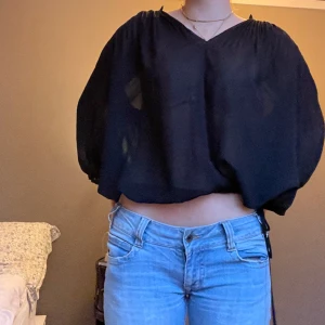 Genomskinlig svart blus - Genomskinlig svart blus från Sand strl 36 men passar även större storlekar. Knyte längst ner så man kan spänna in den. Hör av dig vid frågor🫶🫶💞