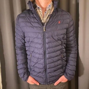 Ralph Lauren jacka - Säljer nu en marinblå dunjacka från Ralph Lauren. Jättesnygg och superbra skick, 9/10. Använd endast ett fåtal gånger och passar perfekt till allt. Nypris 3995kr mitt pris 999kr. Priset är förhandlingsbart vid snabb affär, storleken är small (XL 18-20)