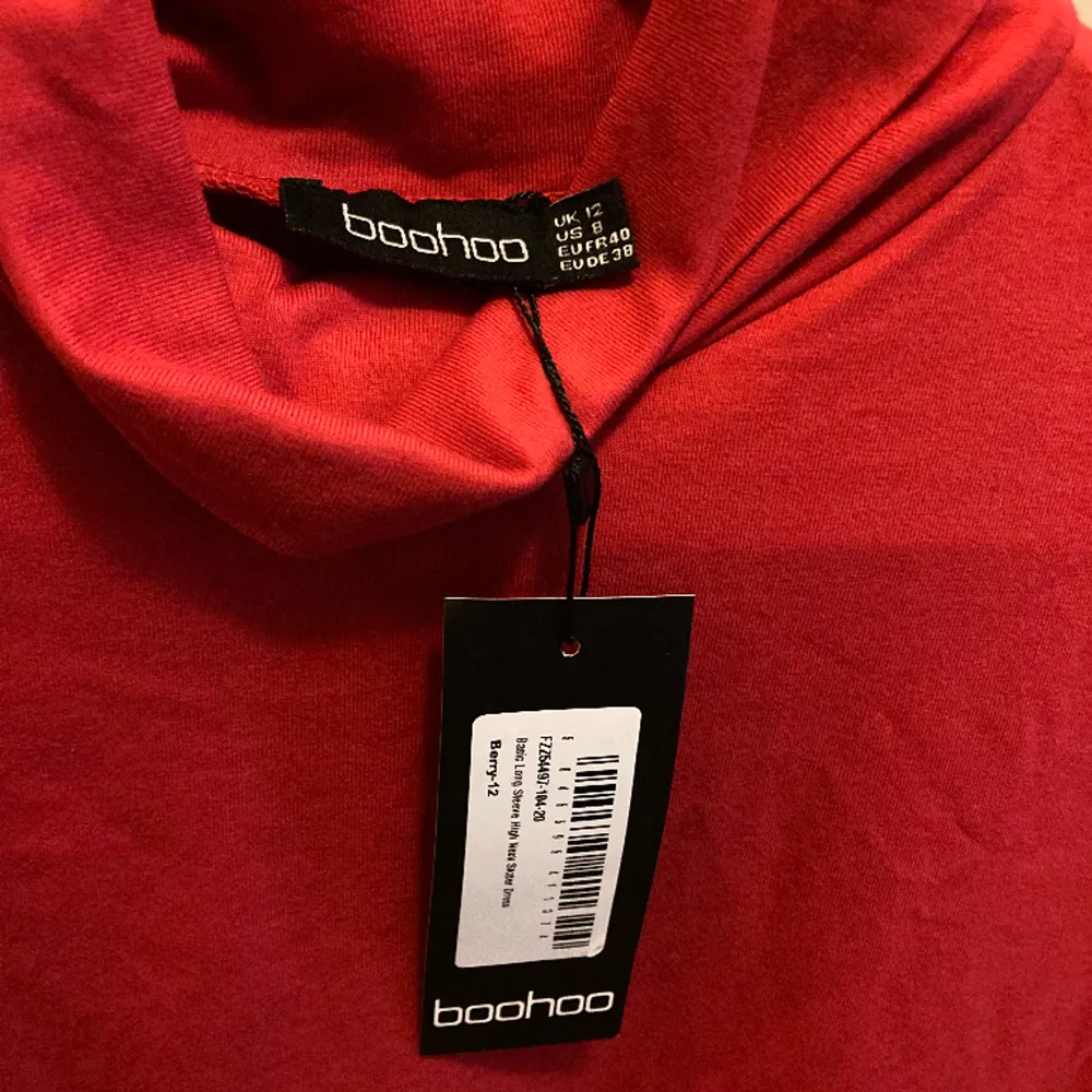 En helt oanvänd röd klänning från märket Boohoo. Vanligt rött tyg och är i storlek M/40. Har en hög halskrage. . Klänningar.