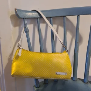 Axelväska - Liten, söt och somrig axelväska i gult med vita prickar. Använd men i mycket fint skick.