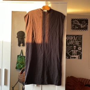Klänning - T-shirtklänning utan ärmar. I använt men välbehållent skick. Mycket snygg till ett par kängor om man så vill.  Frakt 45kr
