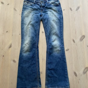 Lågmidjade jeans - Lågmidjade jeans med bootcut, fläck på framsidan