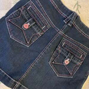 Lowwaist kjol - Så söt jeans kjol med coola tryck på bakfickorna! Köpt second hand utomlands men aldrig använd!