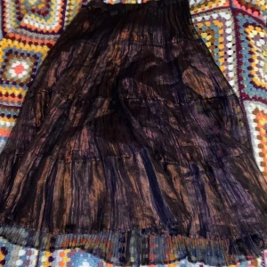 Brun orange glansig kjol  - Kjol köpt på humana i glansigt och genomskinligt material och en underkjol. Storlek och material saknas:( skulle säga att den passar S (lågmidjat) till L då den har resår i midjan! Kommer från rökfritt hem med katt!!:) 