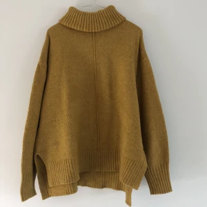 Tjocktröja med turtleneck  - Tjocktröja i en senapsgul färg  Boxig passform med två små slits på båda sidor  Använd men i bra skick Passar någon som har XS-M i storlek 