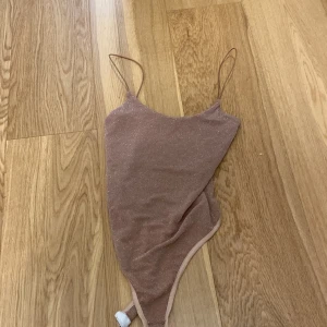 Jättefint glittrigt bodylinne! - Aldrig använd ifrån Pretty little things 💕storlek 36