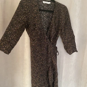 Klänning - Medellång omlottklänning i leopardmönster. NA-KD.