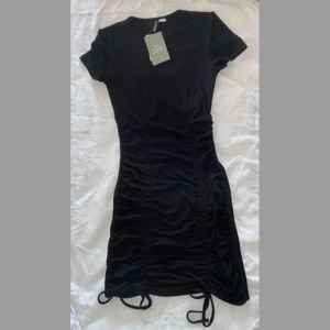 Klänning - Svart klänning från H&M, helt ny. Stretchig och har knytning fram. Figursydd och formar kroppen superfint!😍 Tråkigt nog kom den aldrig till användning hos mig. :( 150kr+frakt💗