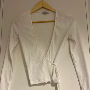 Omlottröja Chiquelle - En omlottröja med snörning från Chiquelle, aldrig använd pga att den är för stor på mig som är 160cm. Tröjan är av ribbad material.