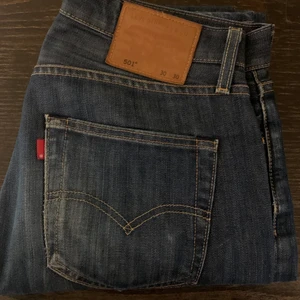 Levis 501 Mörkblå - 501:or i en mörkblå tvätt, med en använd design - straight jeans. Använda en del men det har bara förbättrat utseendet. Köpta nya från butik för ca 900-1000. Inget slitage nånstans.