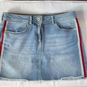 Jeanskjol - Blå jeanskjol med detaljer på sidan 