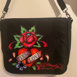 Ed Hardy axelremsväska  - i superbra skick med justerbart band och massa olika fack inuti, kom privat för frågor!!