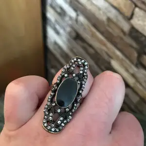 Glittrig ring i bronsfärg med en svart plaststen i mitten.  Kan skickas mot fraktkostnad eller beroende på plats mötas upp. 
