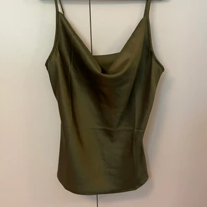 Festtopp - Superfint siden topp i en olivgrön färg, perfekt till fest! Säljer för att den inte kommer till användning! 50kr + 25kr frakt!