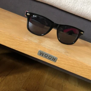 solglasögon  - solglasögon svart ram och rosa kanter. 