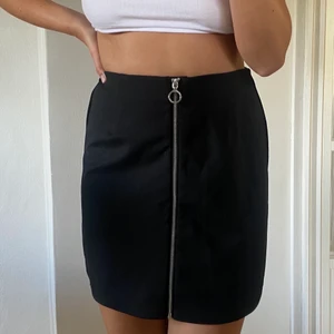 Svart högmidjadkjol med dragkedja  - En svart bekväm högmidjad kjol med dragkedja. Kjolen är i storlek M från Vero Moda. Ganska stretchigt materiel.