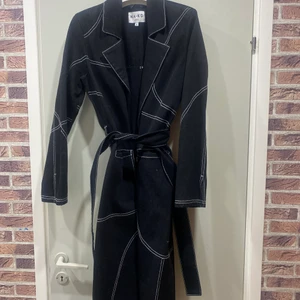 Jeanskappa från NAKD - Lång svart kappa av jeanstyg från NAKD. Går ner till mina vader och jag är 172. Använd kanske 3 gånger totalt! 