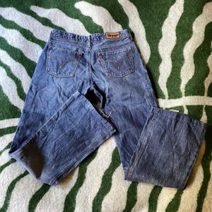 Levis 572 bootcut - Köpta second hand! Finns små slitage längst ner på byxan som ni kan se på bild 1. Trodde jag var lite mer skinny legend än vad jag var så får ej över dem över rumpan</3 tråkigt de är verkligen de perfekta jeansen 🥲🥲 strlk 29x34 enl lapp men skulle säga att de är mer åt 25/26. Lånar bild av säljare Julia Storfeldt här på plick så att ni kan se hur de ser ut på!! 💛☺️